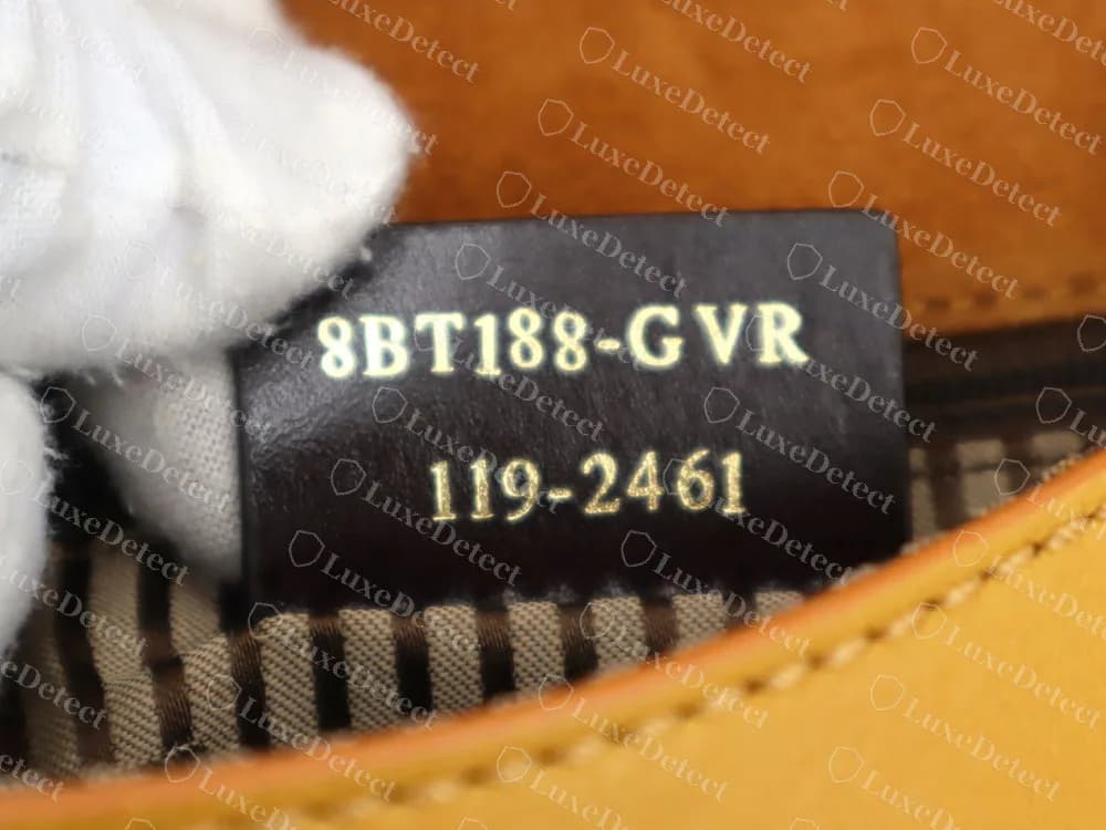 Un bolso de hombro Fendi genuino con una etiqueta de piel oscura en el bolsillo del forro estampada en dos líneas: 8BT188-GVR sobre 119-2461