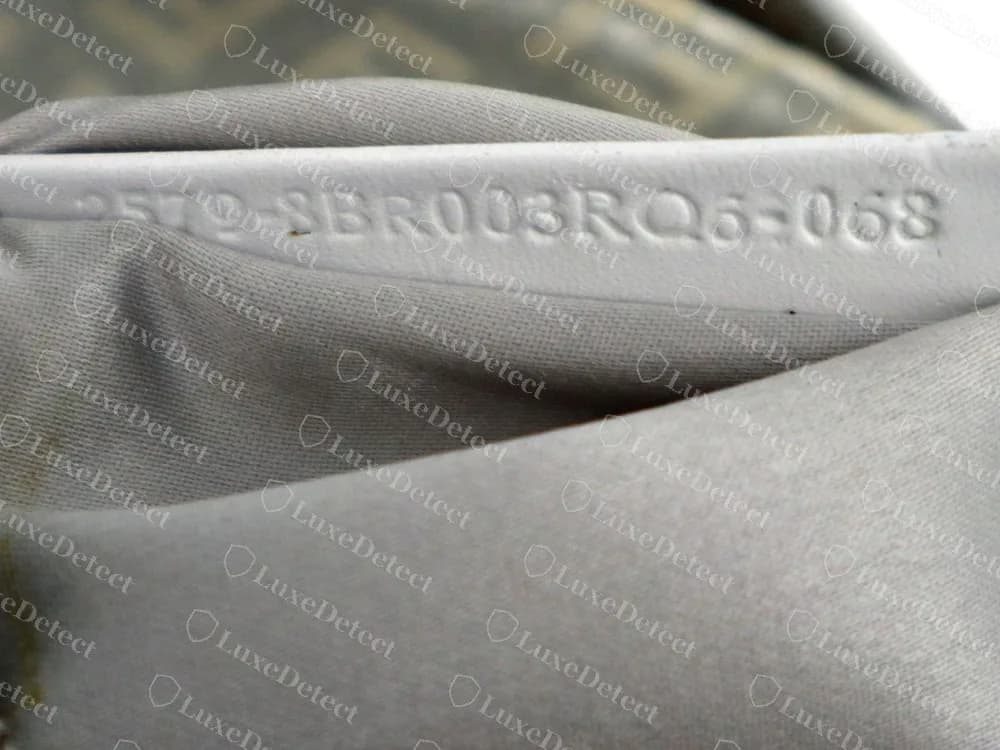 Un baguette Fendi Zucca genuino con el código en relieve en una banda de piel clara del forro, terminado en 8BR003RQ6-068