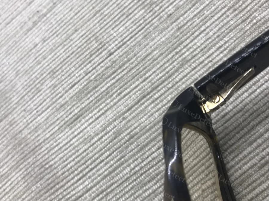 Authenticated Fendi temple-hinge join: a mechanical screw and barrel are visible, but there is no adhesive residue or haze at the seam.