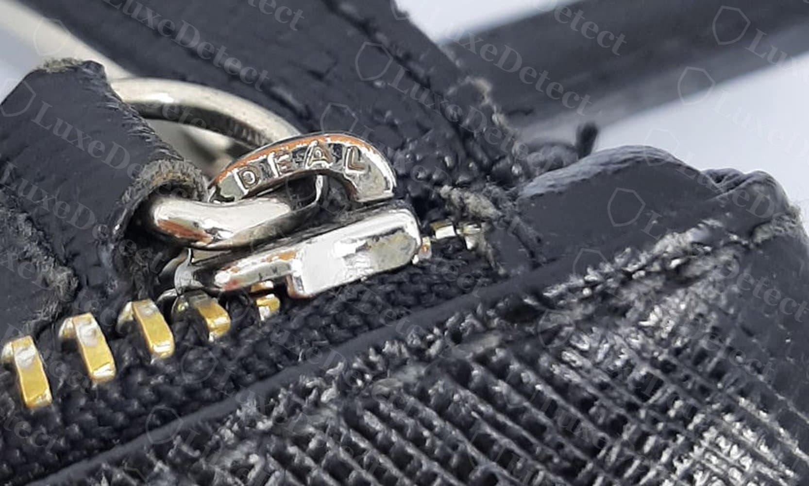 Zipper pull on a bag listed as Furla, stamped "DIESEL" instead — hardware sourced from an unrelated brand entirely.