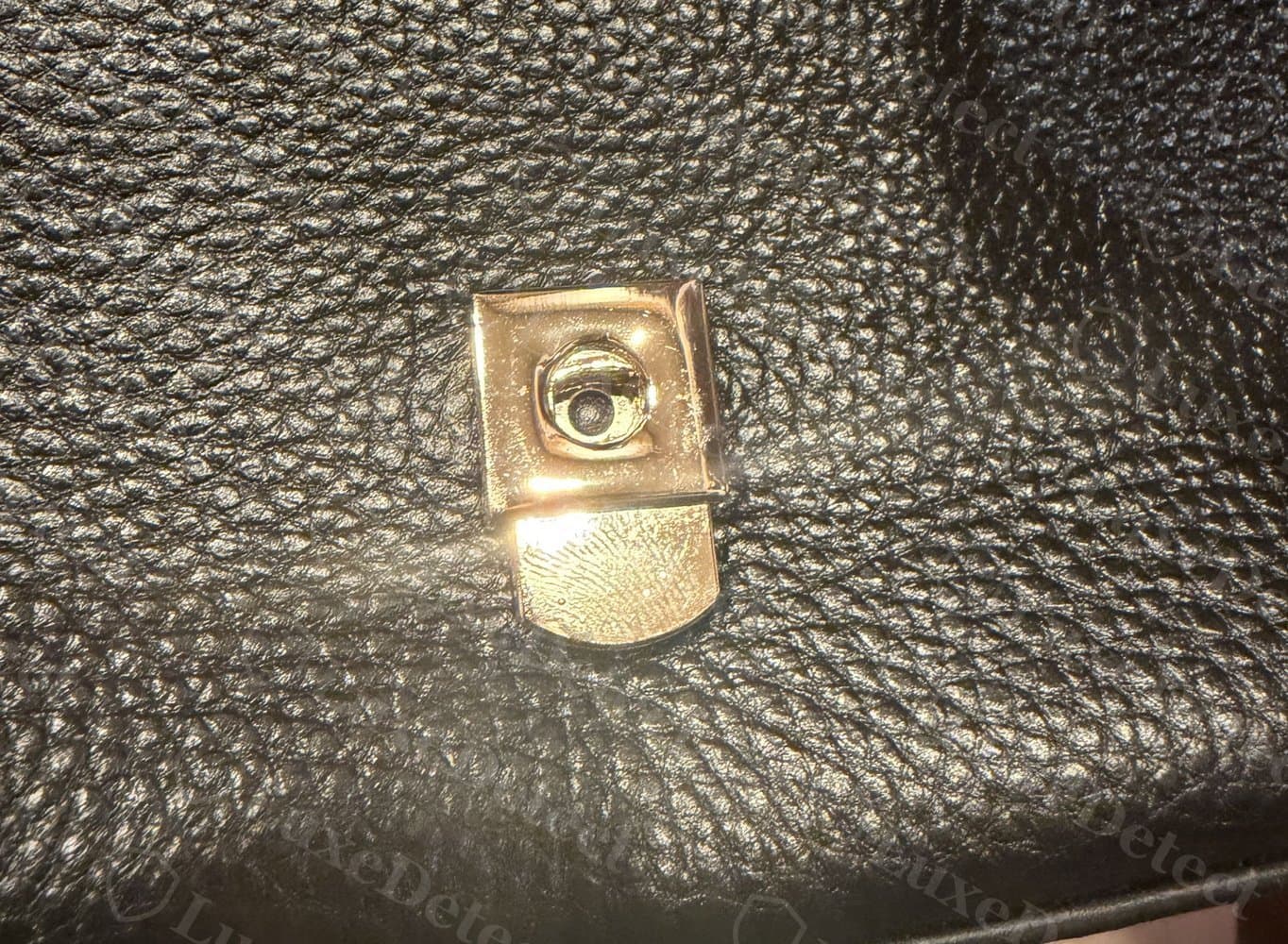 Counterfeit closure hardware: a blank, unbranded gold plate with no engraving where "FURLA" should appear.