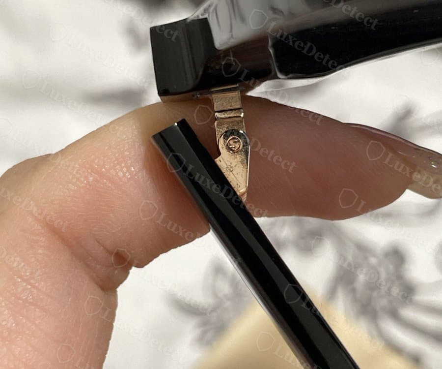 Fake Gentle Monster hinge: a plain flat two-leaf pivot with a single screw and no barrel segmentation.