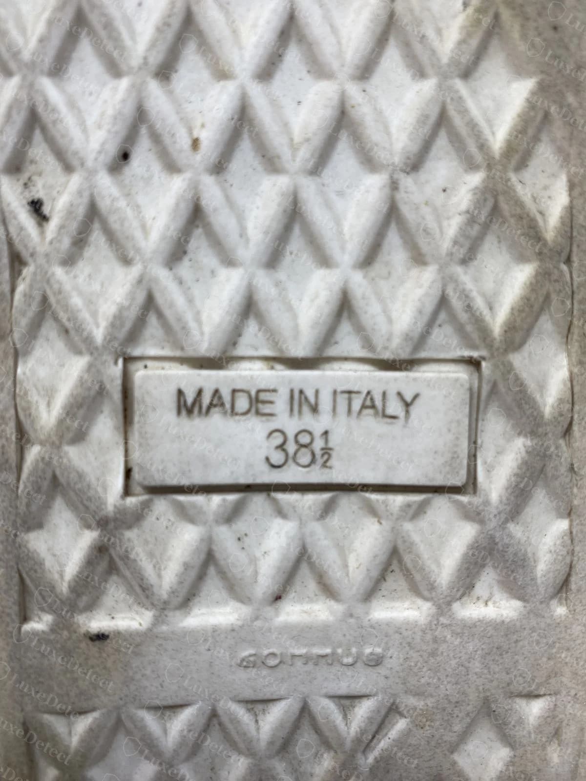 Suela original de dibujo de rombos Giuseppe Zanotti con un recuadro moldeado que dice MADE IN ITALY sobre la talla 38 y media, y una palabra corta moldeada en escritura en espejo en la banda de abajo