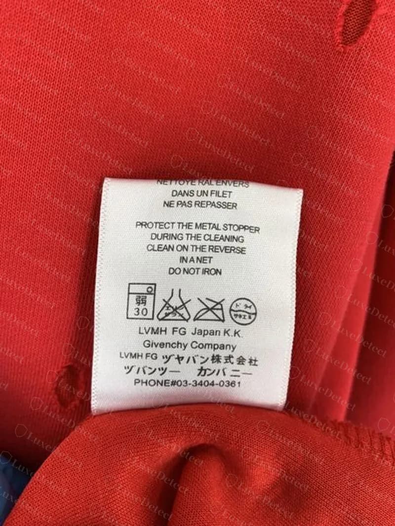 Étiquette d'entretien d'un hoodie Givenchy contrefait avec un bloc qui ne correspond à aucune époque authentique : « LVMH FG Japan K.K. » au-dessus de « Givenchy Company », katakana incohérents (ツヤバン株式会社) et PHONE#03-3404-0361.