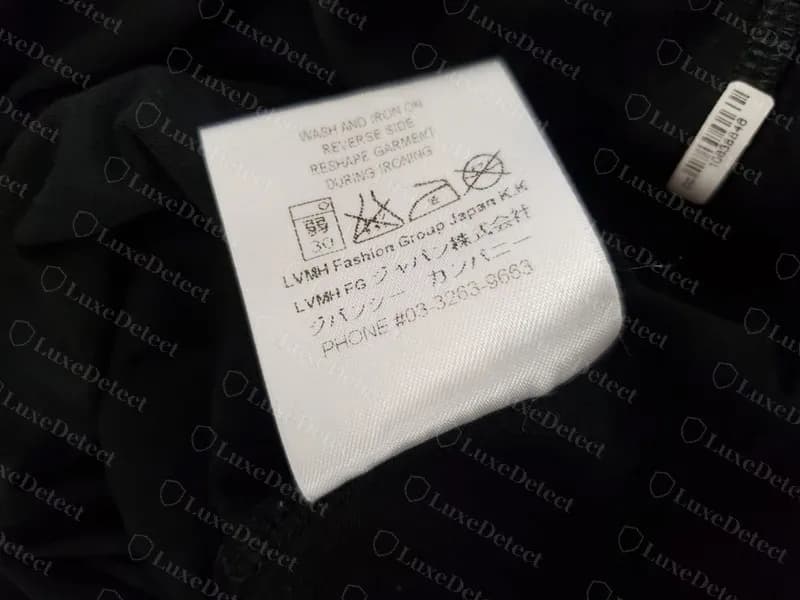 Étiquette d'entretien d'un t-shirt Givenchy que nous avons jugé contrefait, portant le bloc de l'époque 2015 : « LVMH FG ジャパン株式会社 », une ligne ジバンシー カンパニー et PHONE #03-3263-9663. Ce bloc est authentique sur les étiquettes de la saison 2015 ; il ne désigne donc une contrefaçon que si le code de l'étiquette elle-même date d'une année plus tardive.