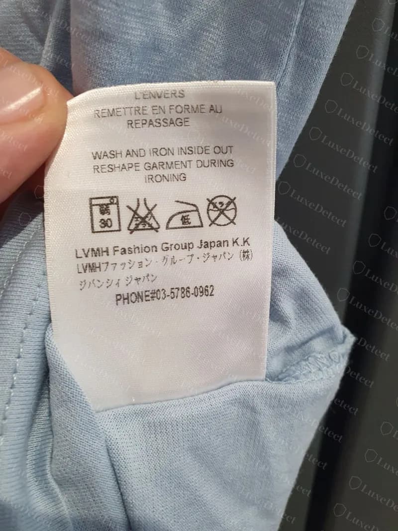 Étiquette d'entretien d'un t-shirt Givenchy authentique avec le bloc de 2016 et après : « LVMH Fashion Group Japan K.K », la ligne complète en katakana, la ligne ジバンシィ ジャパン et PHONE#03-5786-0962.