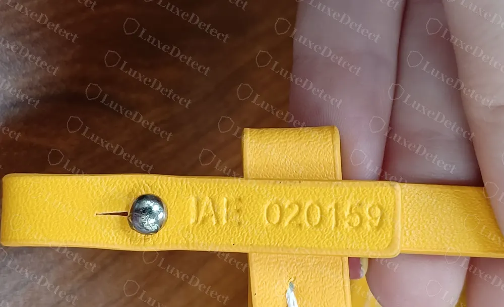 Counterfeit yellow Goyard Anjou Mini heat-stamped VAE 020159 on its interior leather tab