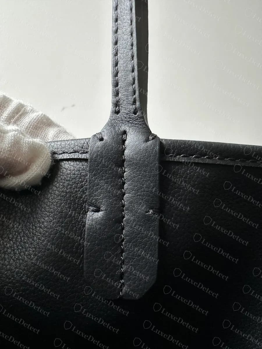 Counterfeit Goyard Anjou handle attachment, shown for construction comparison against the genuine tab above
