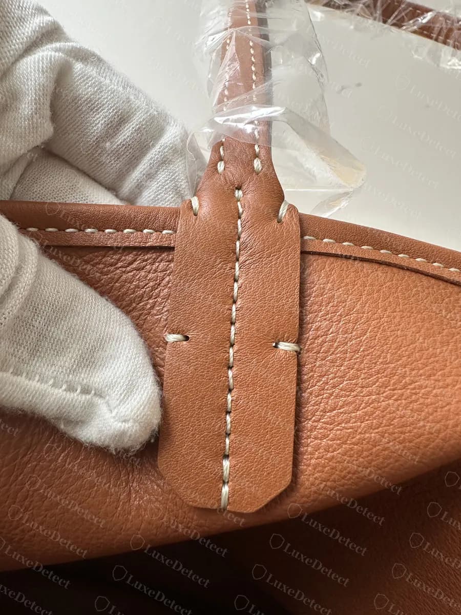 Genuine Goyard Anjou handle attachment: a pointed leather tab stitched down both sides and through the centre where the handle meets the body