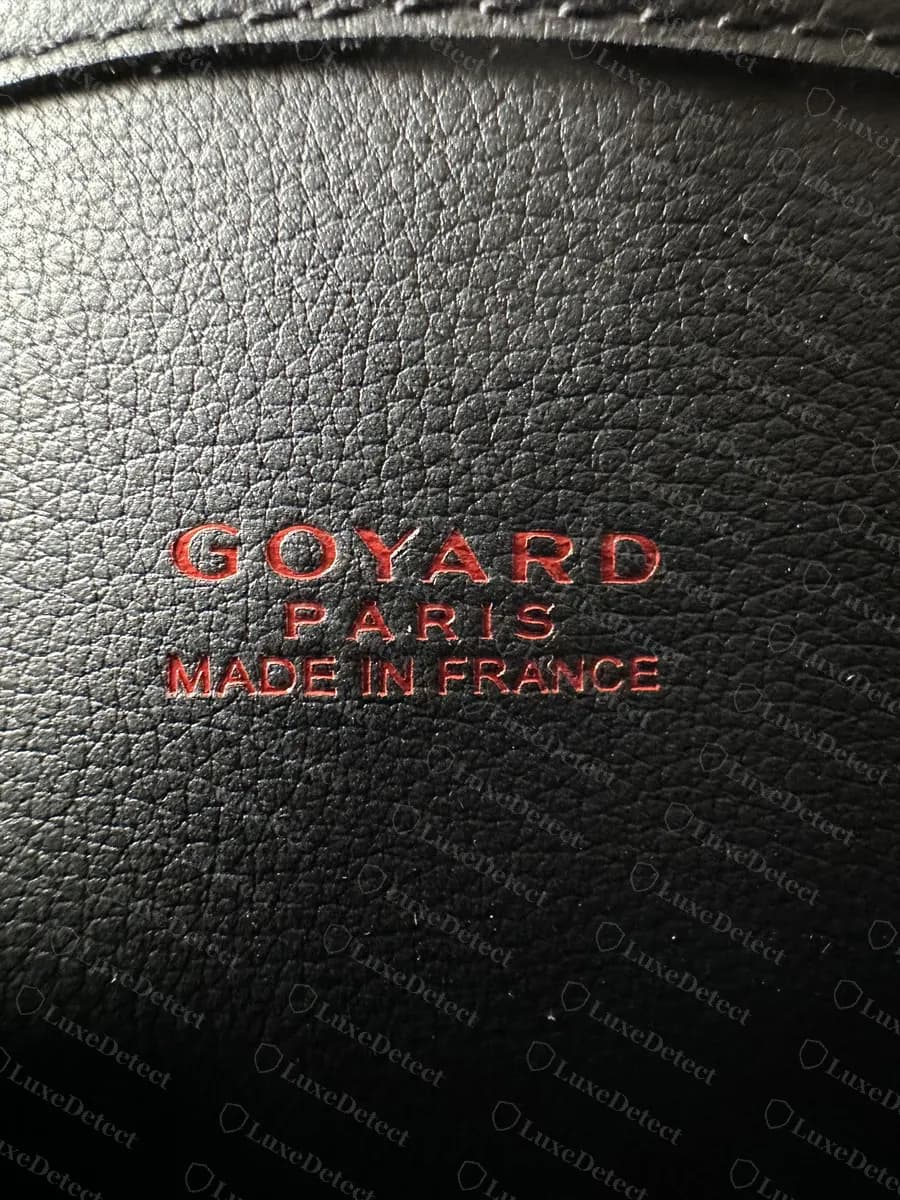 Counterfeit Goyard Anjou leather-side stamp reading GOYARD PARIS MADE IN FRANCE, shown for comparison