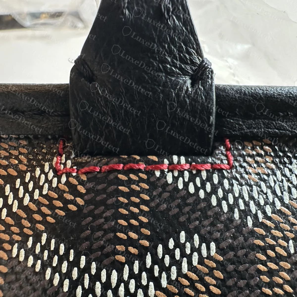 Genuine Goyard Artois handle tab with a line of red thread along the seam where it meets the canvas