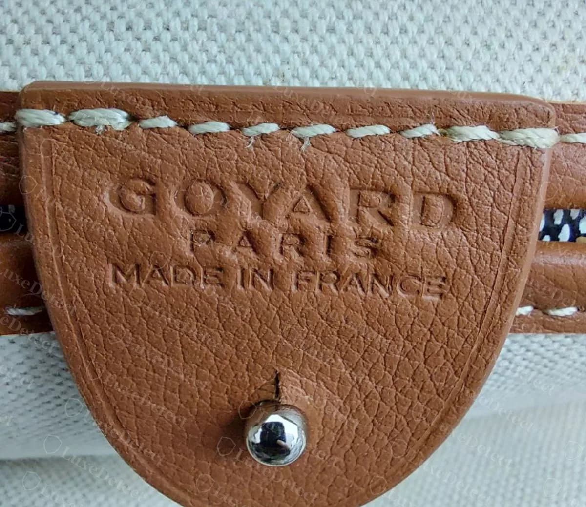 Genuine Goyard Artois interior tab blind-stamped GOYARD PARIS MADE IN FRANCE, fastened over a metal push-stud
