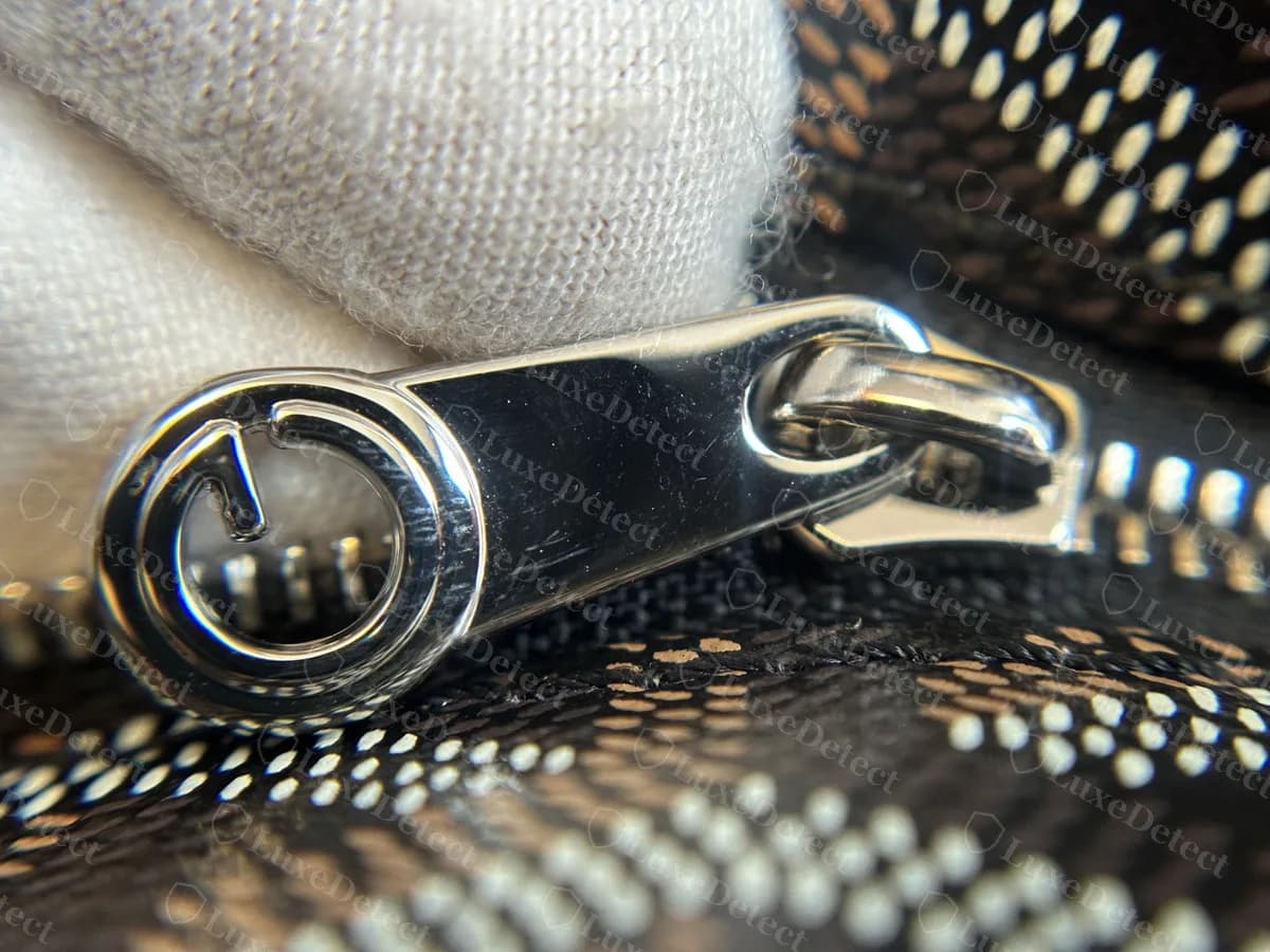 Genuine Goyard Artois zip pull: polished metal tab ending in a round ring with a G cut-out