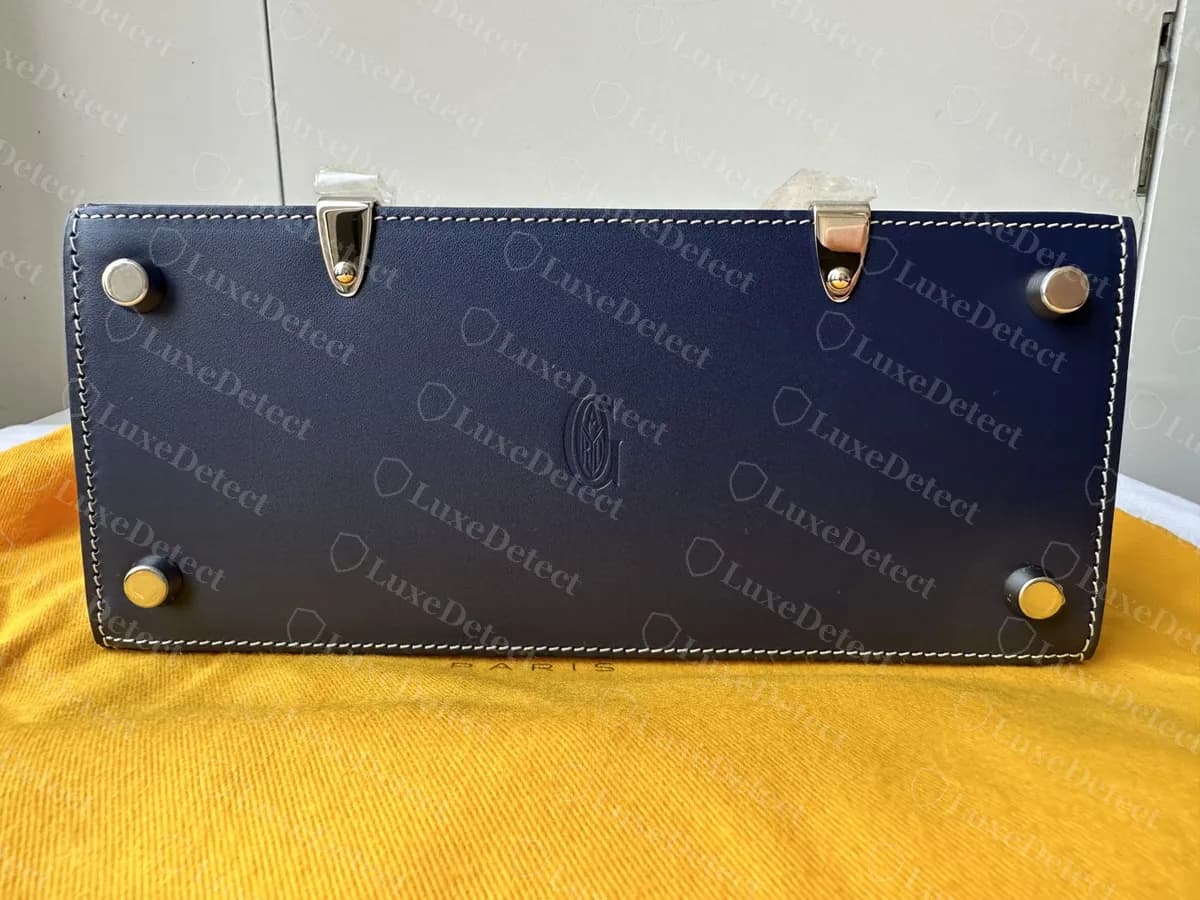 Genuine Goyard Saigon Structure base: four metal feet near the corners and the circular G emblem pressed into the centre