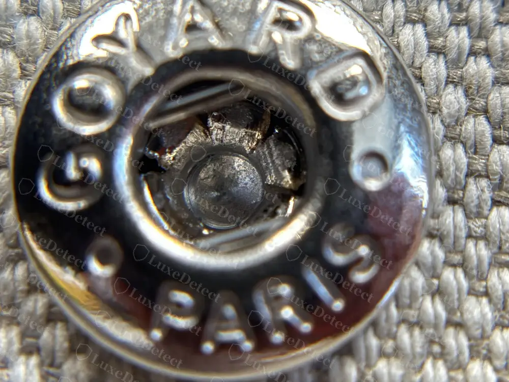 Genuine Plumet snap socket engraved GOYARD and PARIS around the rim, set into the woven canvas that lines the flap