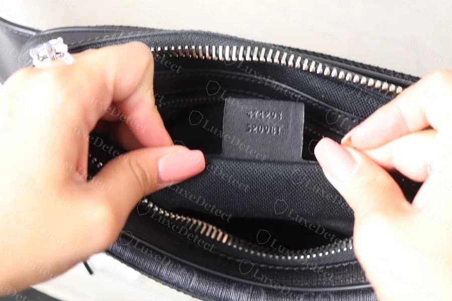 Genuine GG Supreme canvas belt bag in the grey/black colourway, zip closure, showing the woven monogram texture and a leather-trimmed zip pull