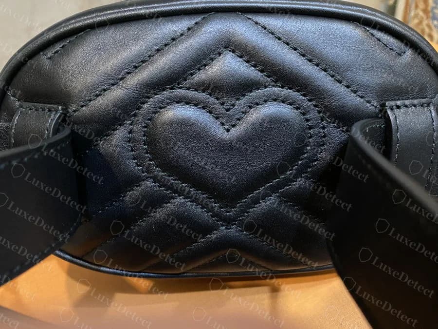 Genuine heart-quilted back panel on a matelassé Gucci belt bag, showing consistent stitch depth and a centred heart motif within the surrounding chevron lines