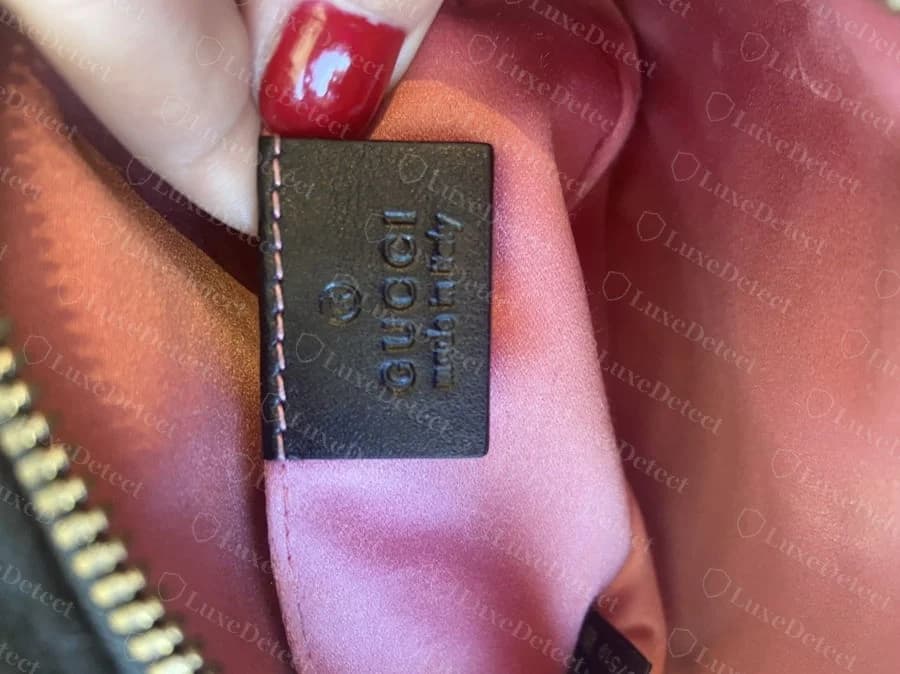 Genuine "GUCCI made in italy" embossed leather patch, evenly stamped with consistent letter depth across the whole line