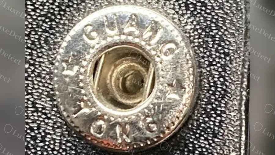 Fake snap stud stamped GUANG TONG, a factory name, around the post