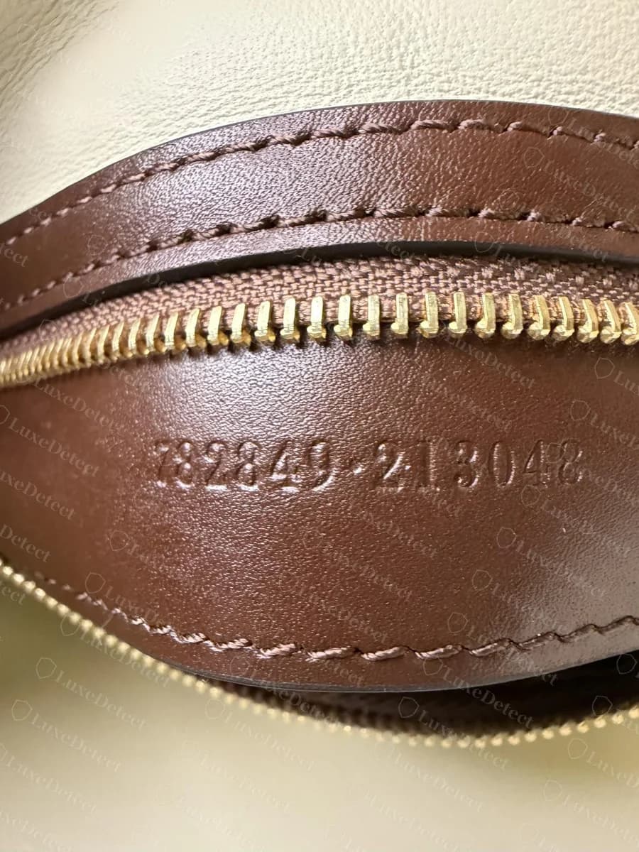 Sello de serie del Gucci Jackie 1961 falso: "782849-213048" en dígitos grandes y muy separados, presionados a fondo en la tira de piel
