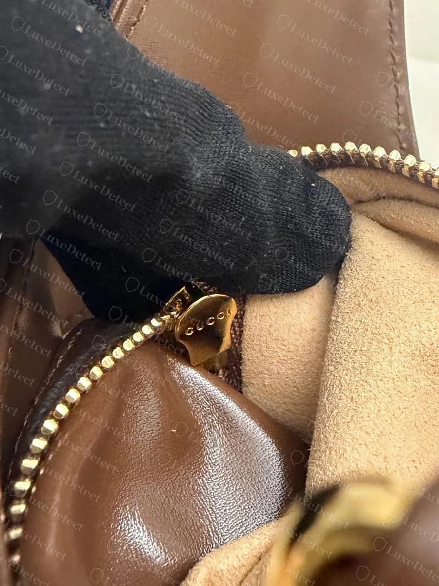 Tirette de fermeture éclair d'un Gucci Jackie 1961 authentique : une petite tirette dorée gravée « GUCCI », du même or chaud que le fermoir