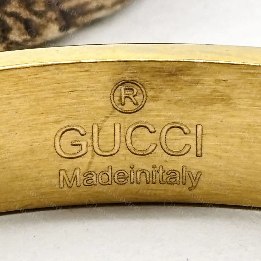 Counterfeit Gucci bangle stamped (R) GUCCI above Madeinitaly with the words run together