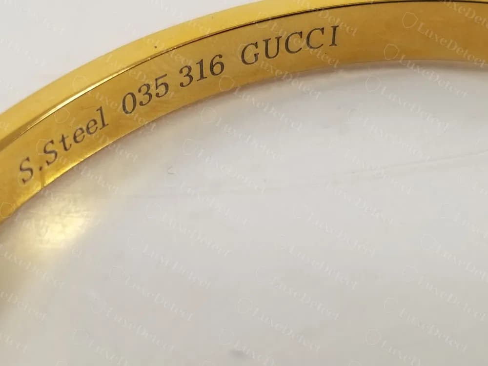 Brazalete rígido dorado Gucci falso con S.Steel 035 316 GUCCI grabado por dentro del aro
