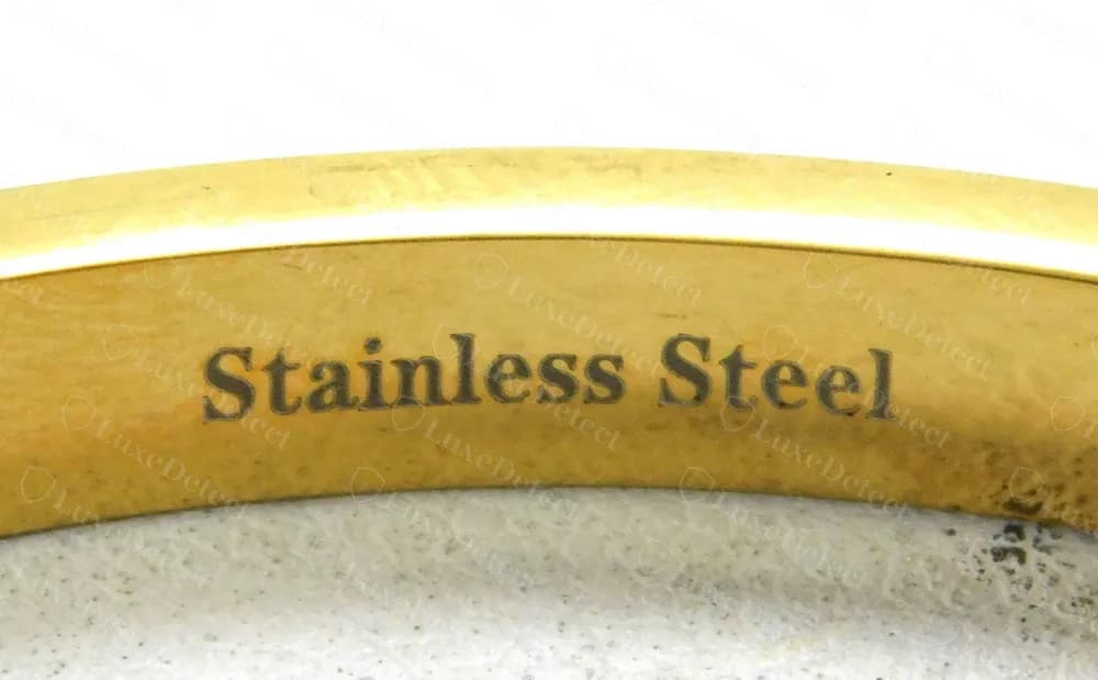Brazalete rígido dorado Gucci falso con Stainless Steel grabado por dentro del aro