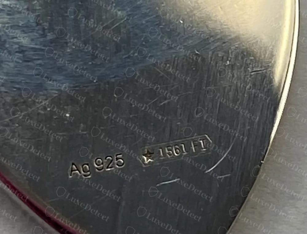 Genuine Gucci silver heart tag, reverse: Ag 925 stamped beside a lozenge holding a star, a number and a two-letter code