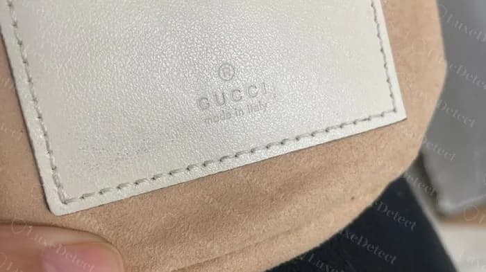 Genuine Marmont mini bucket interior patch with the registered mark, GUCCI and made in italy stamped into ivory leather over beige suede lining