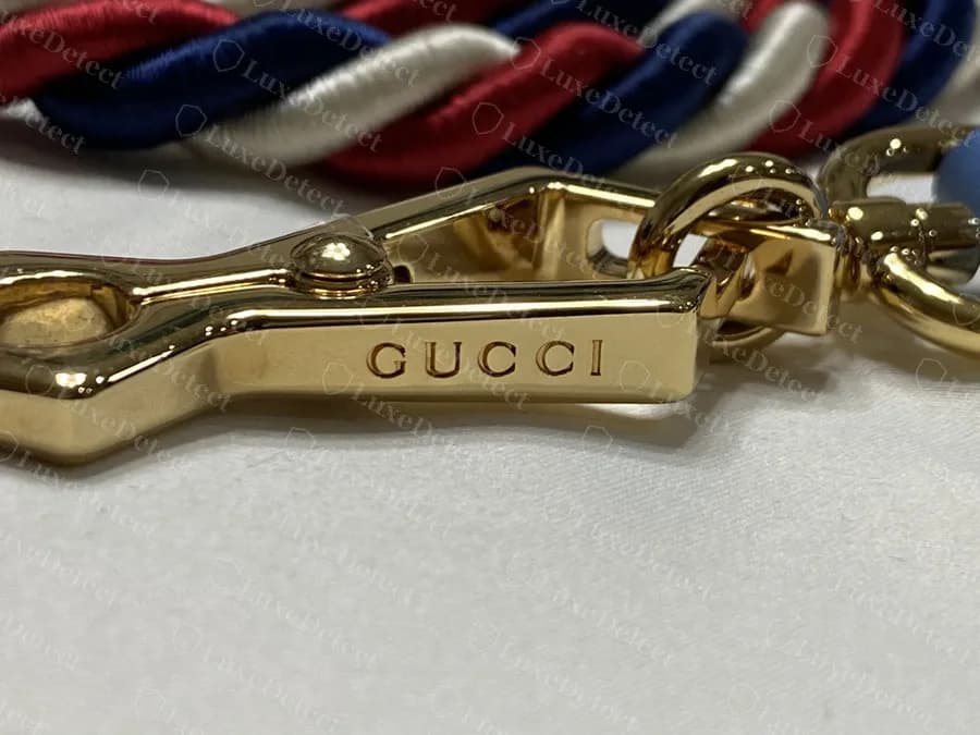 Genuine Sylvie strap clasp engraved "GUCCI" along the shank, attached to the braided red, white and navy rope strap