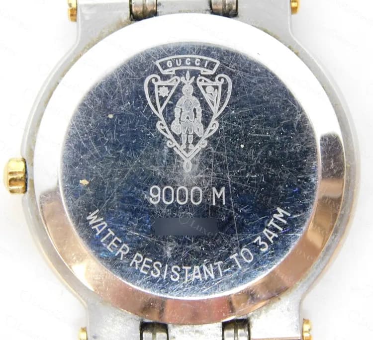 Genuine Gucci 9000 M caseback: crest, model line 9000 M and water resistance text, serial blurred