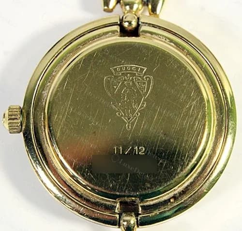 Fundo da caixa de um bracelete Gucci original com bezel intercambiável: brasão com uma linha de referência 11/12, número de série desfocado
