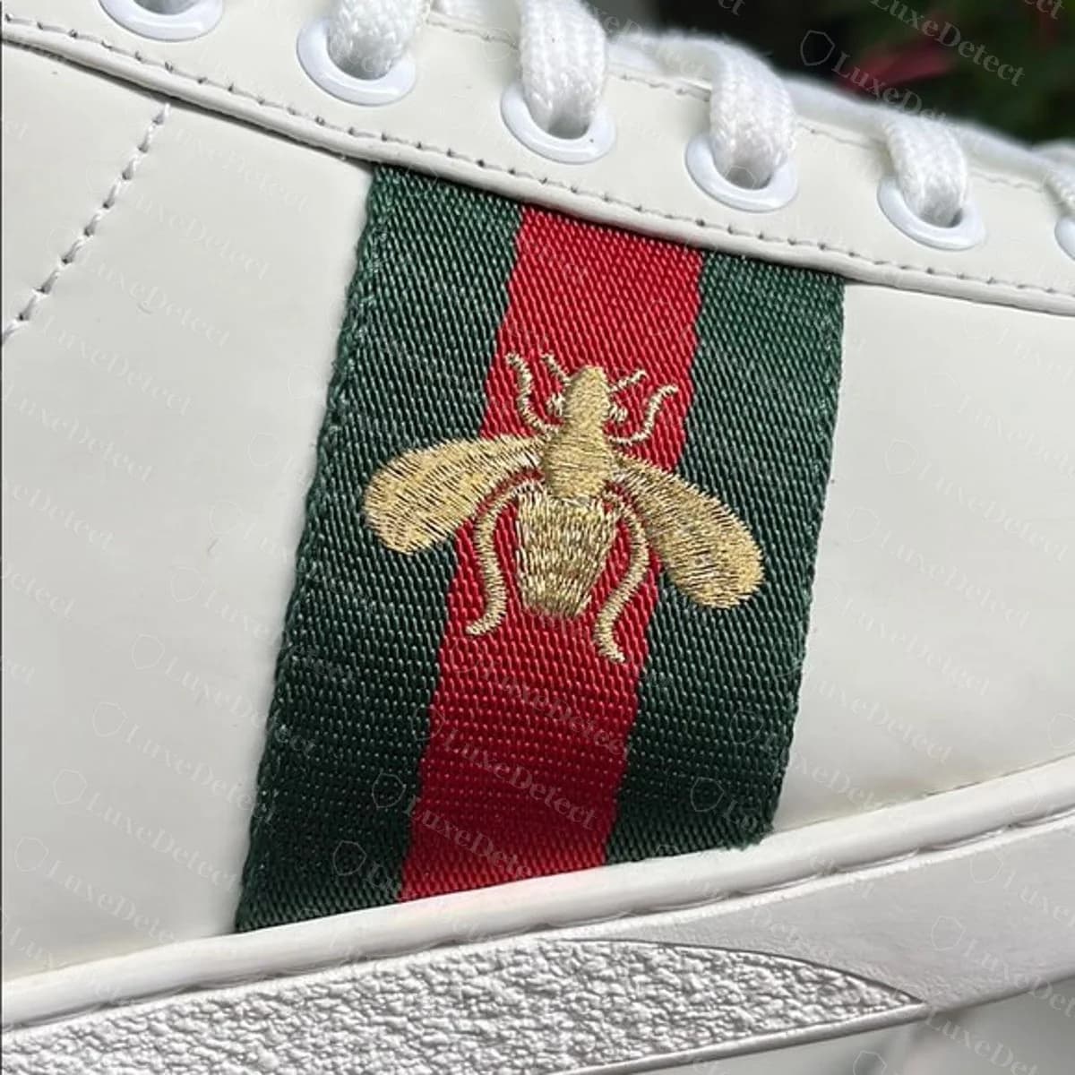 Genuine Gucci Ace bee on the Web stripe — fine, even gold stitching, smooth wing and body outlines, thin tapered legs, both wings matched in size