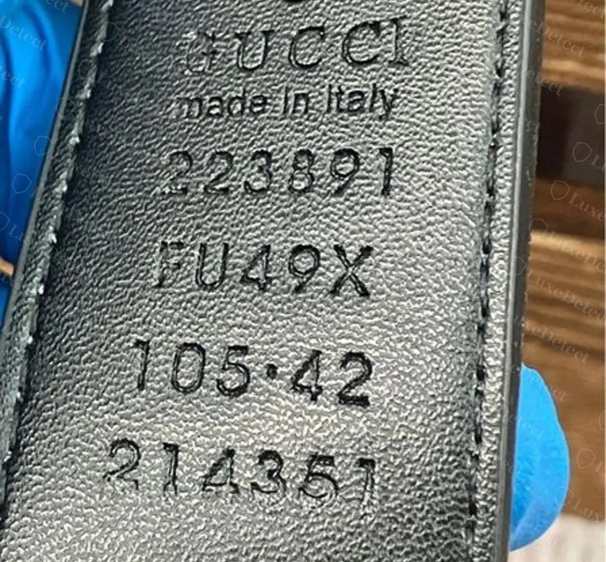 Sello de un cinturón falso que dice 223891, FU49X, 105·42, 214351, prensado con limpieza y difícil de distinguir del sello original