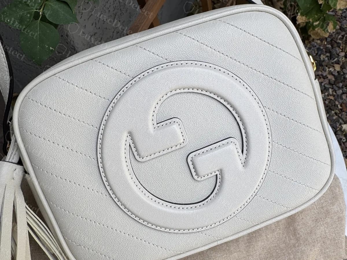 Genuine white leather Blondie camera bag: a GG embossed into the front with stitched outlines, on diagonal quilting, with a tassel at the side