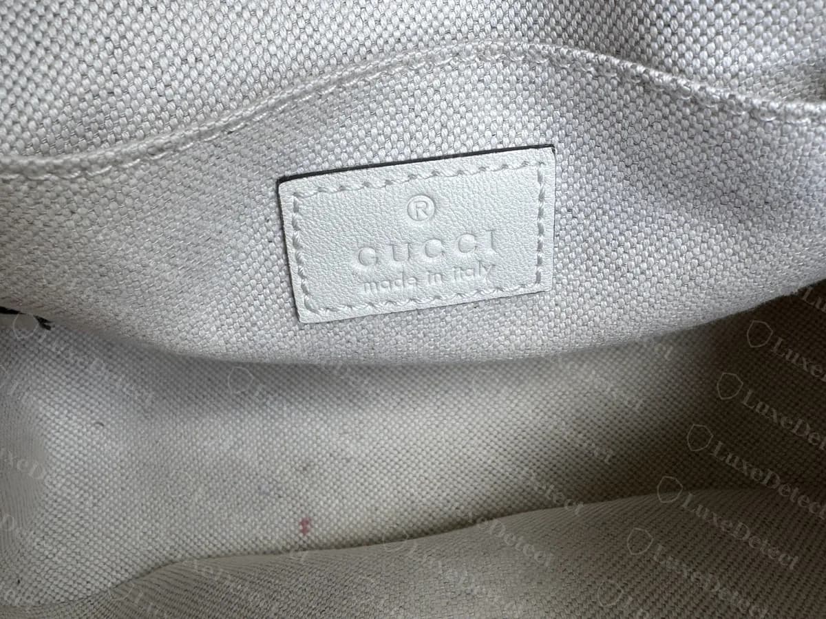 Genuine Blondie camera bag lining with a white leather tag reading GUCCI with a registered mark, and made in Italy beneath