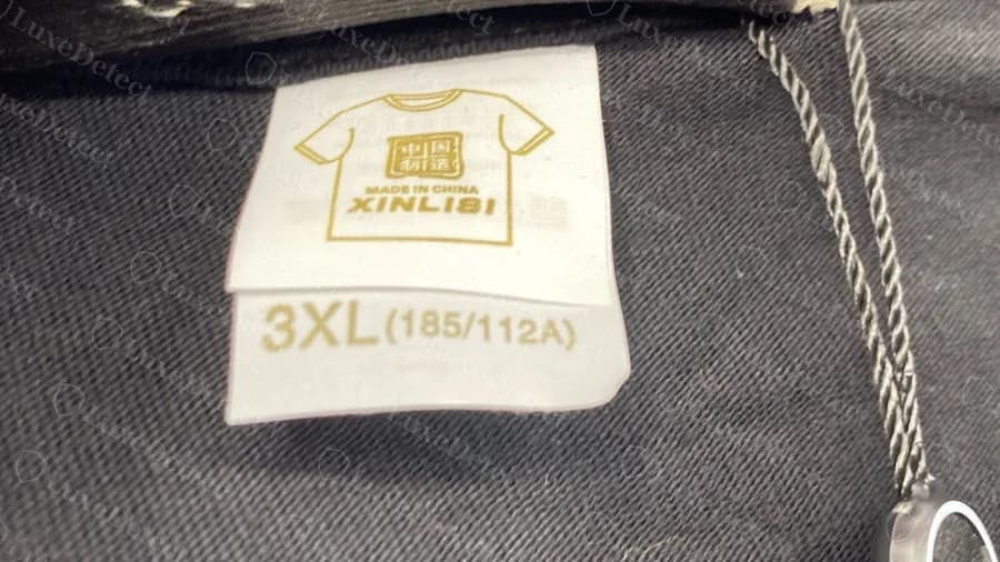 Faux t-shirt Gucci : une étiquette de taille tierce générique, d'un fabricant chinois de t-shirts vierges, cousue à l'intérieur du col