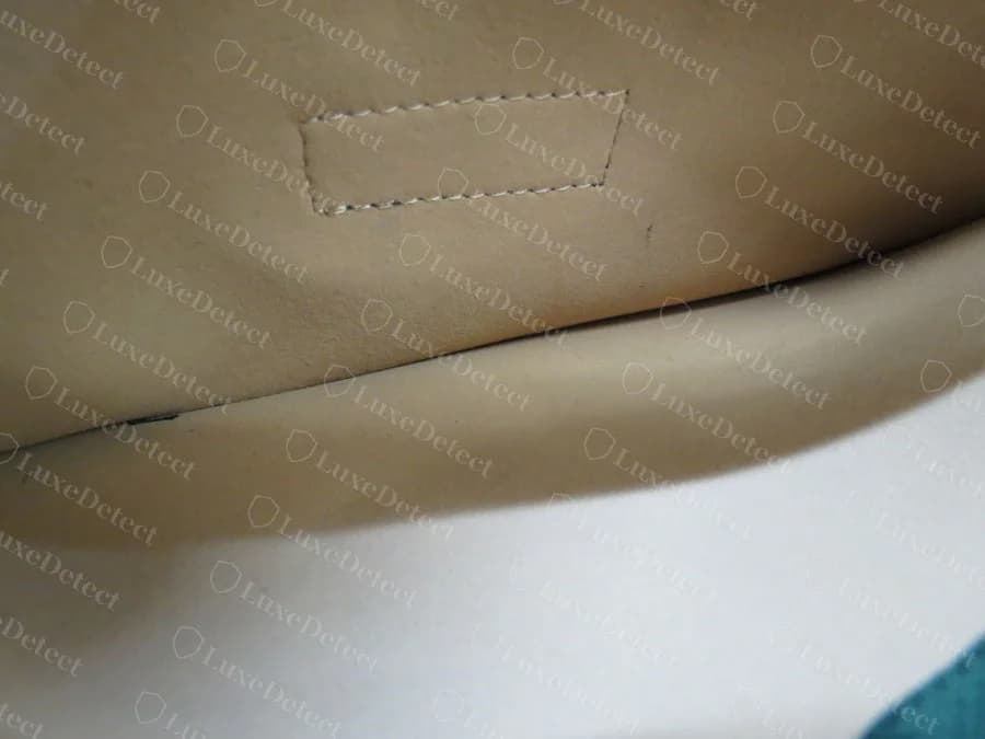 Counterfeit Flora tote interior, the stitched rectangle where a control tag belongs is completely empty, no tag sewn in at all, just bare lining and stitching