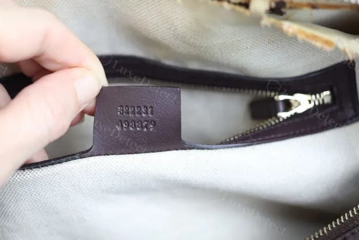 Authentic Gucci interior leather tag — "GUCCI made in Italy" heat-stamped cleanly into a fine-grain leather tab with consistent depth
