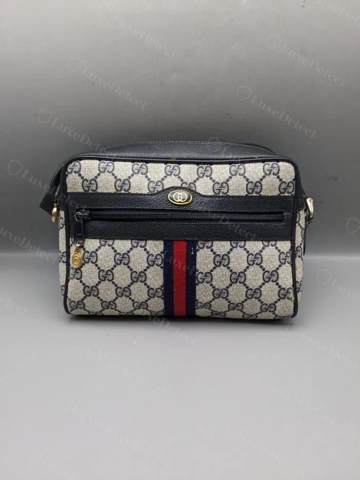 Authentic GG Supreme Ophidia front panel — the woven green-red-green web stripe with tight even stitching along both edges, and the gold GG plaque cleanly cast with a visible gap between the two interlocking Gs