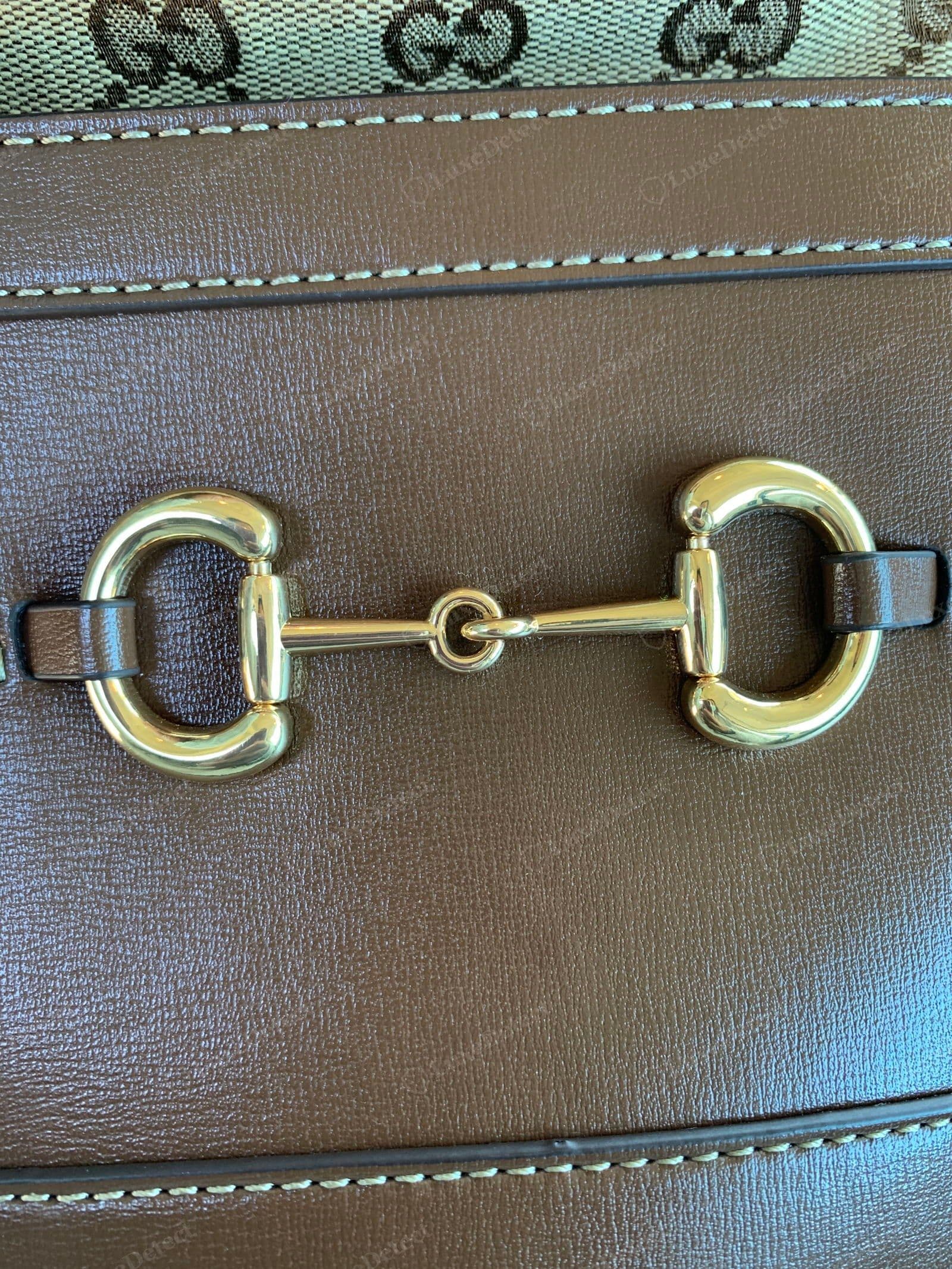 Counterfeit Gucci Horsebit 1955 hardware — the front horsebit clasp and the metal strap ends, showing a light casting with soft edges and uneven plating