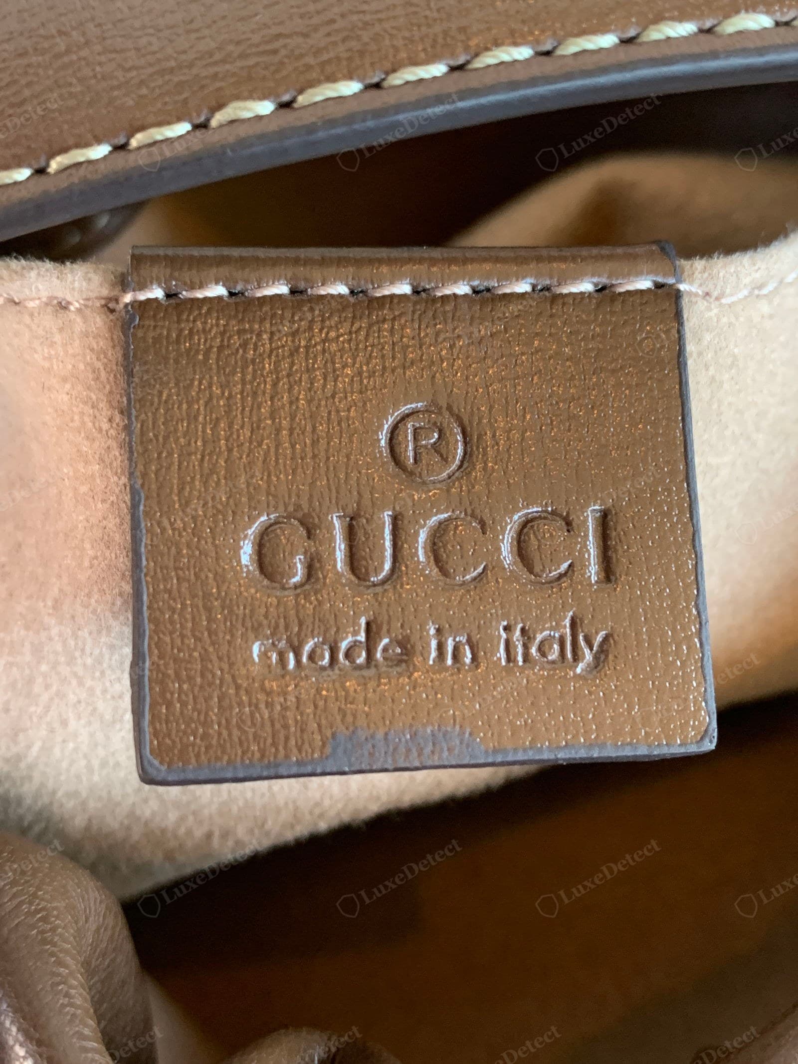 Counterfeit Gucci Horsebit 1955 heat stamp — the interior "GUCCI" / "made in Italy" embossing, shallow and uneven in a non-house font
