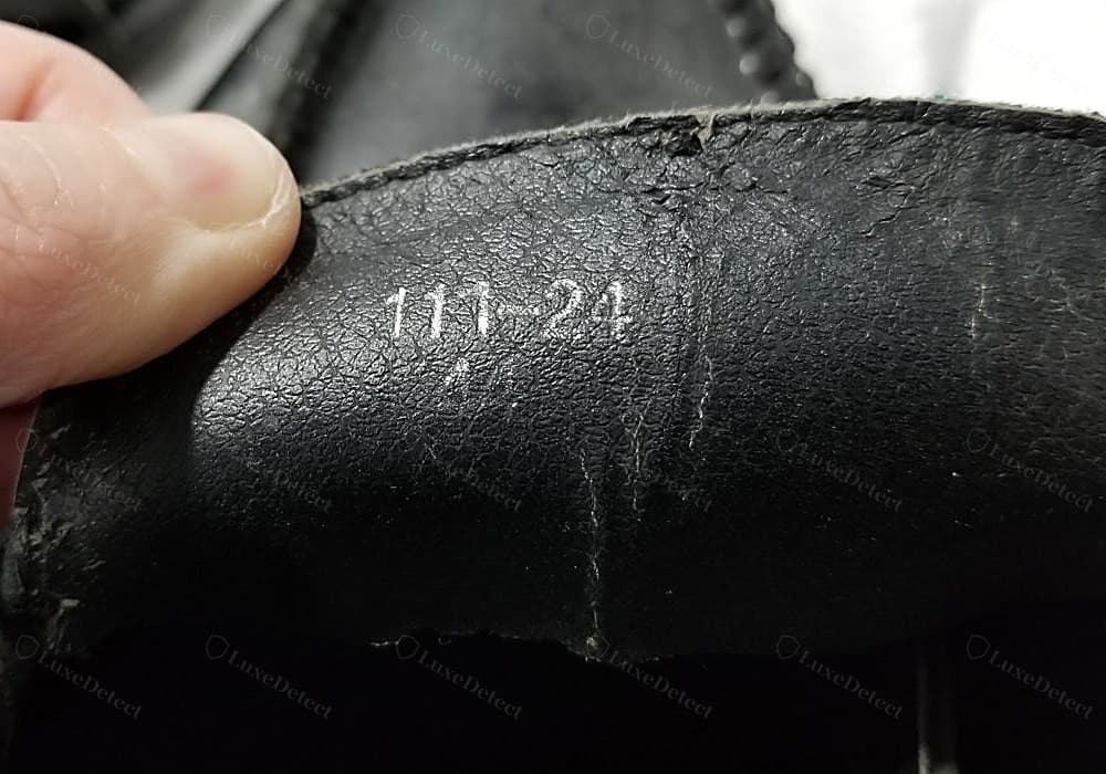 Código interno Gucci falsificado — sem placa de metal, um código de lote tosco “111-24” carimbado à mão em branco diretamente sobre o forro preto da palmilha, que não é um número de estilo Gucci de seis dígitos