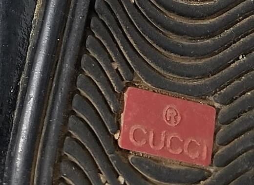 Gefälschte Gucci-Driver-Sohlenplakette – der eingeformte Name liest sich „CUCCI“, weil das G seinen Querstrich verloren hat, daneben ein überdimensioniertes ®