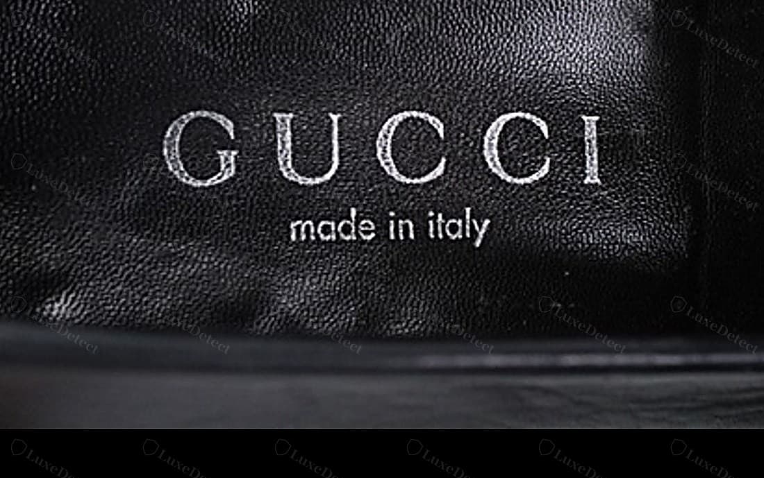 Genuine Gucci insole heat stamp — "GUCCI" widely and evenly tracked in an even-weight serif over "made in italy" in lower case, pressed cleanly into the leather in silver foil