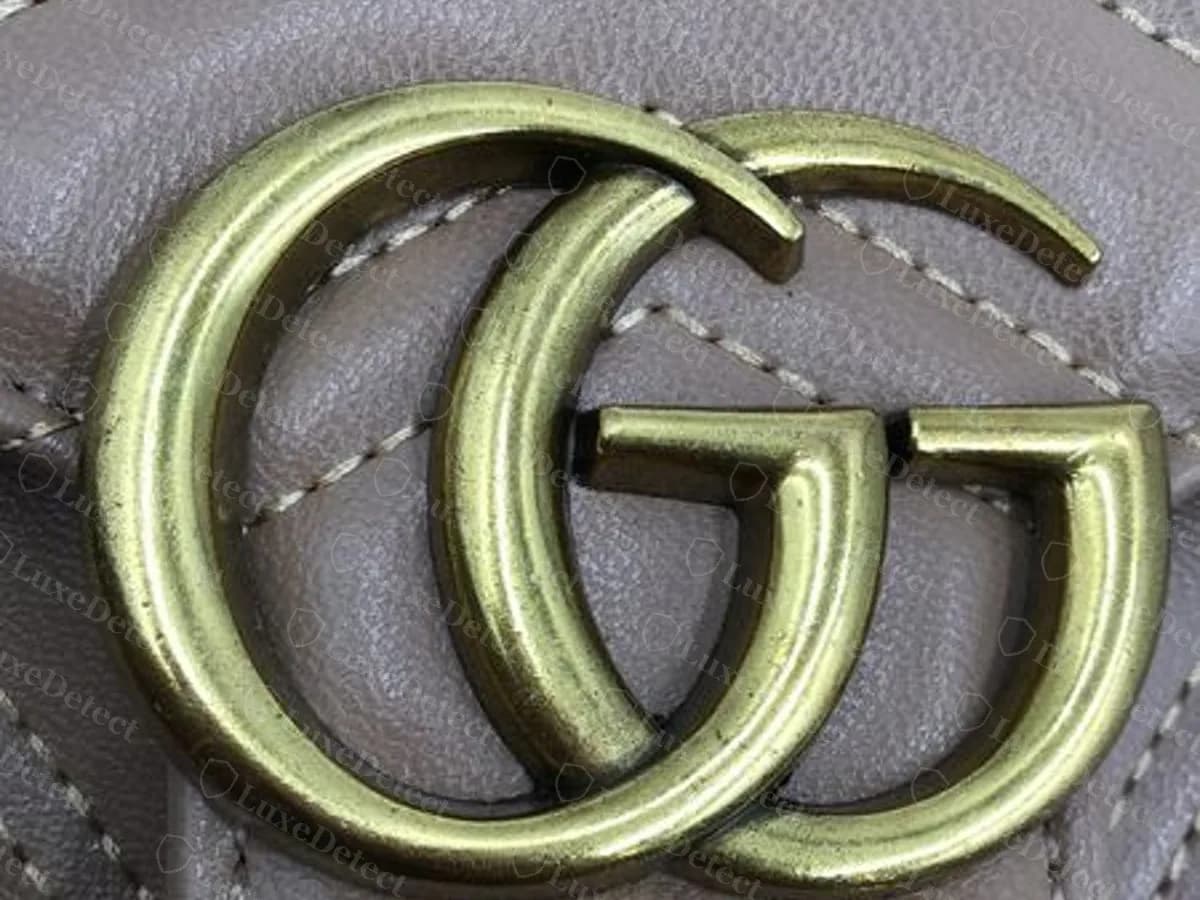 Olive-green tinted GG on a counterfeit grey-taupe Marmont; brass colour varies and is not a reliable check