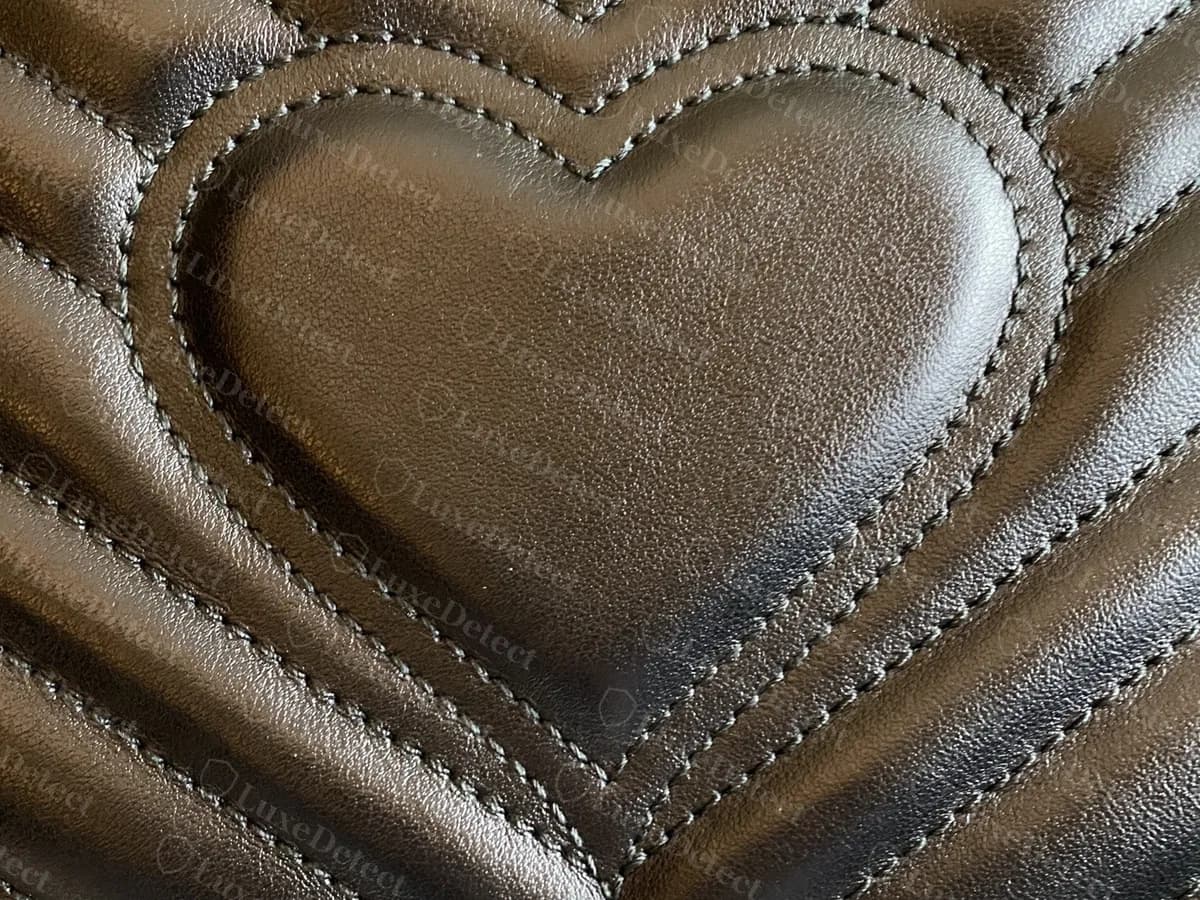 Genuine black GG Marmont with a quilted heart at the centre of the chevron pattern, the stitching following the heart's outline