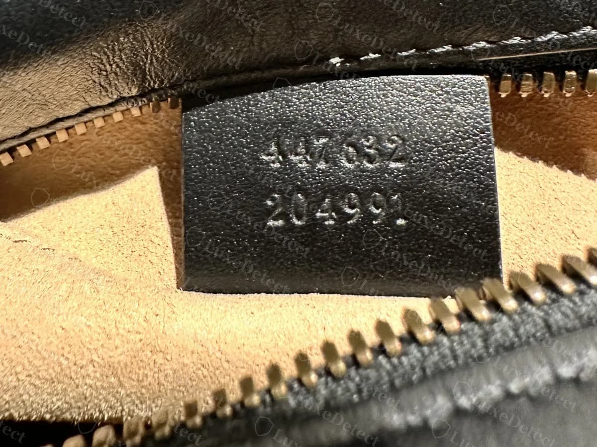 Reverso de una etiqueta interior de Marmont con dos filas de seis dígitos, 447632 sobre 204991; el mismo par aparece también en bolsos falsos, así que no es una prueba