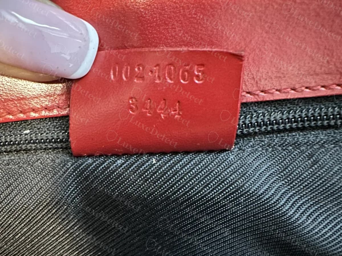 Echtes älteres Gucci-Etikett aus rotem Leder mit der Prägung 002 · 1065 über 3444
